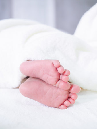 Close up of newborn baby feet on white blanketの写真素材