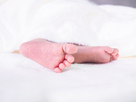 Close up of newborn baby feet on white blanket