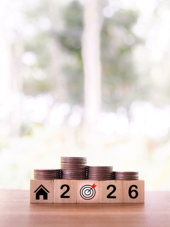 Wooden blocks with the number 2026 and stack of coins. The concept of saving money for house, Property investment, House mortgage, Real estate in year 2026の写真素材