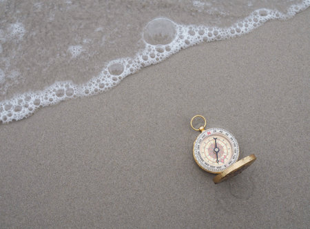 Compass with ocean waves on a sandy beach. The concept of world tourism day, Searching the right directions and Travelの写真素材