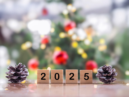 Wooden block number 2025 and pinecones with Christmas light bokeh background. Merry Christmas and Happy New Year 2025の写真素材