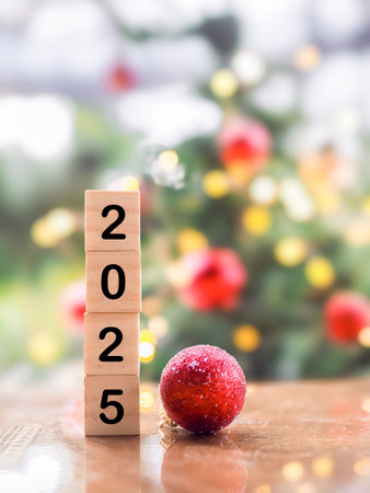 Wooden block number 2025 and red ball with Christmas light bokeh background. Merry Christmas and Happy New Year 2025の写真素材