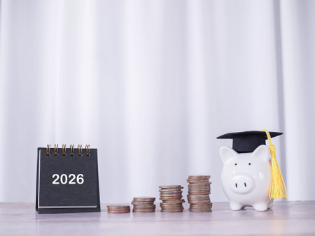 Study goals, 2026 Desk calendar, Piggy bank with graduation hat and stack of coins. The concept of...