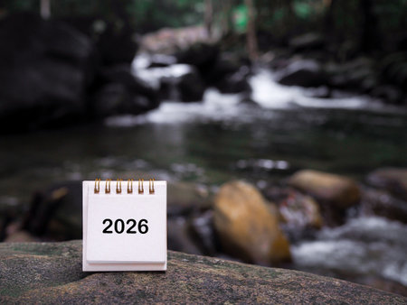 2026 desk calendar on the rock with waterfall as background. Resolution, Goal, Action, Planning, and manage to success business.の写真素材