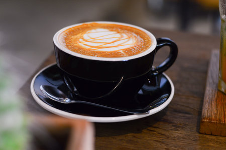 A cup of hot art latte coffee on wooden background