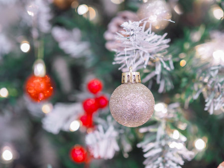 Close-up of silver Christmas ball hanging on Christmas tree with Christmas light backgroundの写真素材