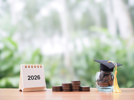 Study goals, 2026 Desk calendar, Glass bottle with graduation hat and stack of coins. The concept of...