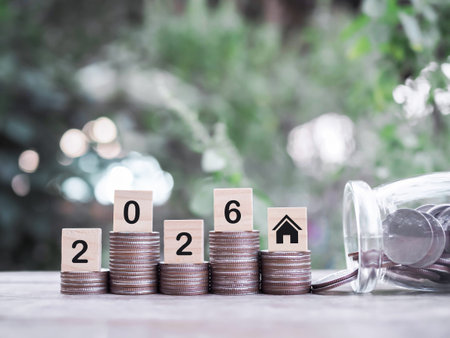 Wooden blocks with the number 2026 on stack of coins. The concept of saving money for house,...