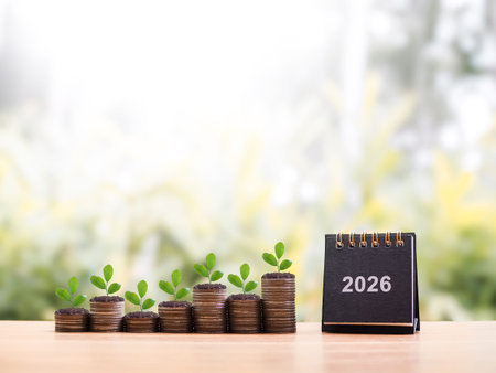 2026 desk calendar, Plants growing up on stack of coins. The concept of saving money, Financial,...