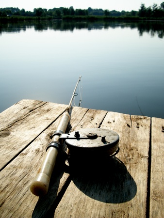 spinning on a wooden bridge at the lakeの写真素材