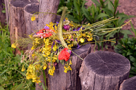 bouquet of wild flowers lying on a wooden stumpの写真素材