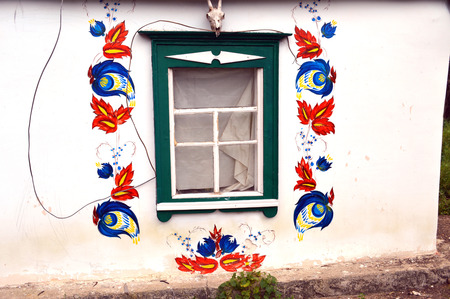 facade of the Ukrainian hut with a painting around the windowの写真素材