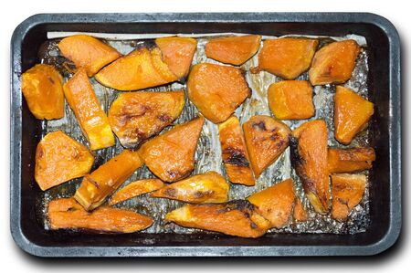 baked pumpkin slices in a rectangular pan on a white backgroundの写真素材
