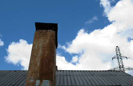 slate roof rusty pipe clouds and electric poleの写真素材