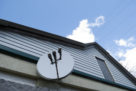 satellite dish on the wall of the house on a sunny day