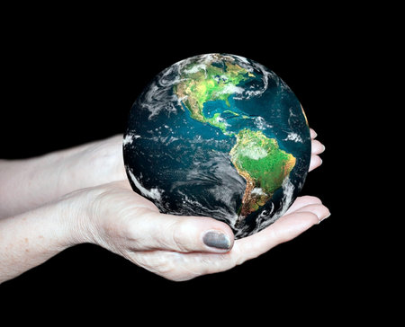 Earth in the hands on a black backgroundの写真素材
