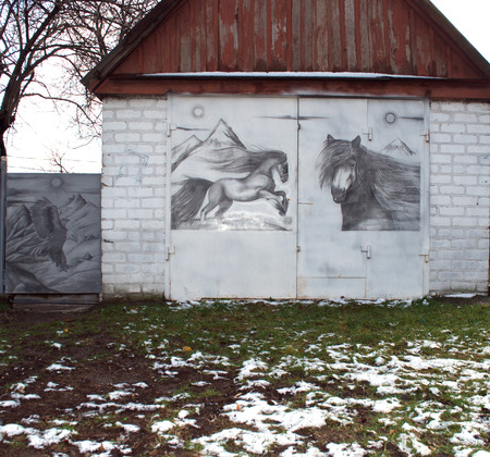 garage with iron gates and drawing horsesのeditorial素材