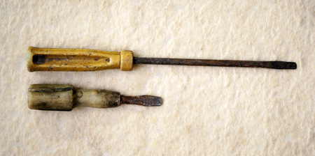 two old rusty screwdrivers on a light backgroundの写真素材