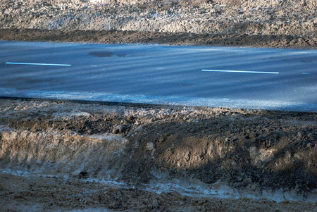 asphalt road with markings and a number of lying clayの写真素材