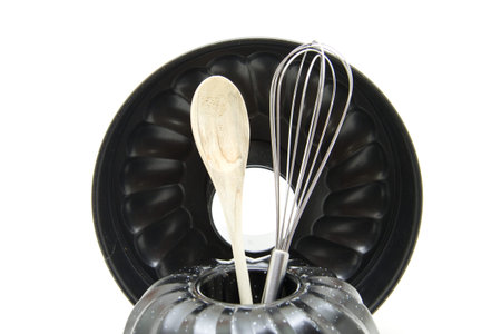 Cakes baking tin with whisk and wooden spoon