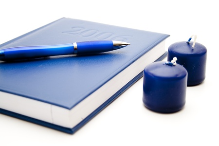 Wax candle with book and ballpoint penの写真素材