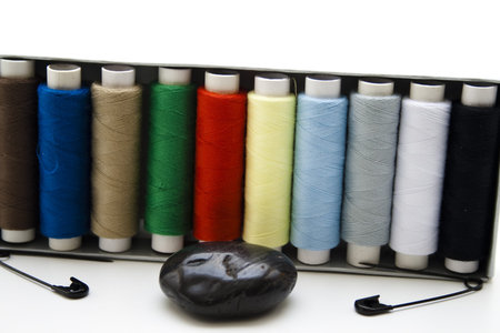   Sewing cotton roles with safety needle and stone