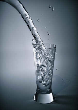 Pure stream of water pouring into a glassの写真素材