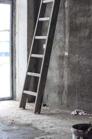 Metallic ladder inside the room with cement walls, home improvement. Vertical imageの写真素材