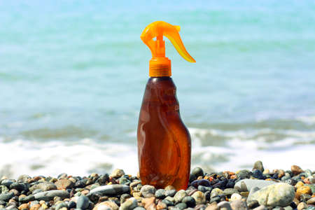 Oil spray beauty product bottle for summer advertisement mock up. sea beach with blue waterの写真素材