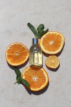 Transparent beauty product bottle laying on a slices of oranges. Idea for citrus scented shampoo or lotion for mock upの写真素材
