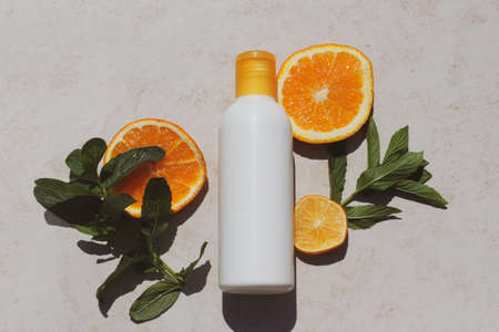 White beauty product bottle laying on a slices of oranges. Idea for citrus scented shampoo or lotion for mock upの写真素材