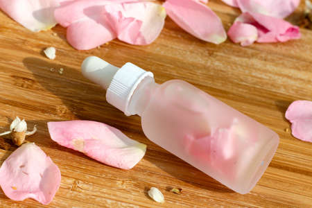 A clear bottle with natural rose petals inside for bio beauty product commercialの写真素材
