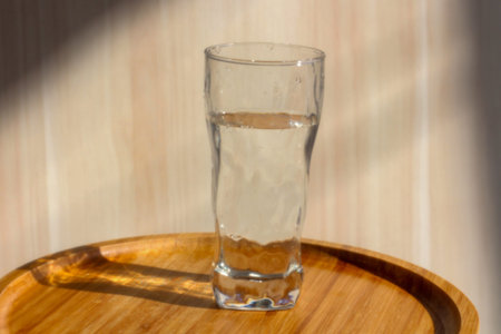 A glass of water standing on the small table. Healthy lifestyle morning