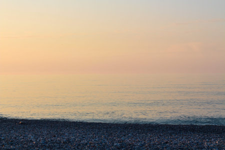 Beautiful sunset on the rocky beach . Soft peaceful water composition