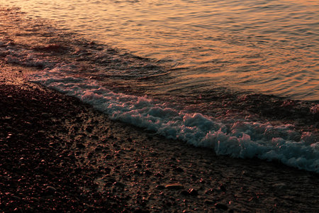 Beautiful sunset on the rocky beach . Soft peaceful water composition