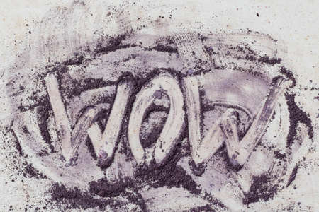Wow inscription drawn by purple color powder paint on a neutral backgroundの写真素材