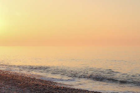 Beautiful sunset on the rocky beach . Soft peaceful water compositionの写真素材