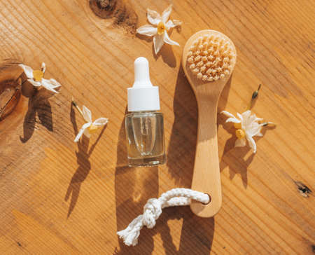 Spa natural treatment idea: wooden brush and beauty product bottle on a natural wooden background. Idea for eco natural cosmetics.の写真素材
