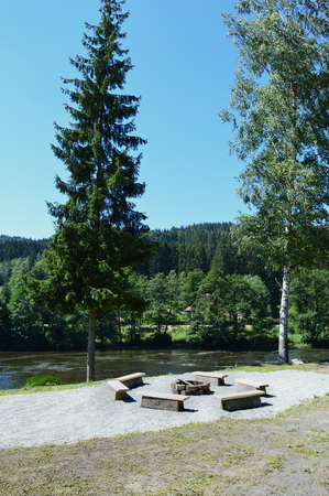 view on fire pit with stone benches near the river in the wildの写真素材