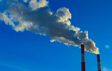 The pipe of the plant emits harmful substances into the atmosphere. Close-up on a sky backgroundの写真素材