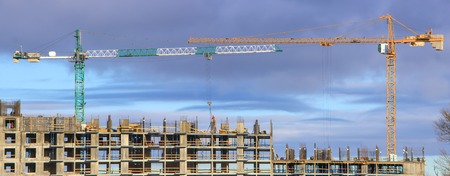 tower crane against the blue sky, the process of building a multi-storey buildingの写真素材