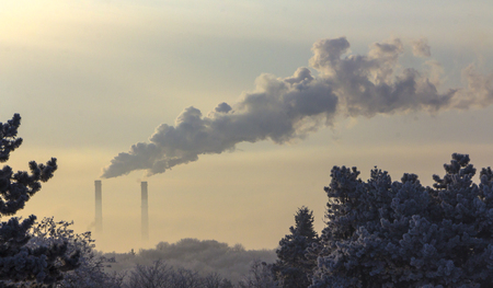 The pipe of the plant emits harmful substances into the atmosphere. Close-up on sky backgroundの写真素材