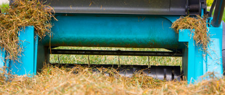 Gardener Operating Soil Aeration Machine on Grass Lawn.