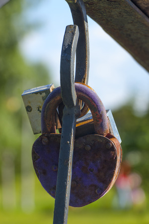 Vintage colorful padlocks heart shaped on blurred background, symbol of love.の写真素材