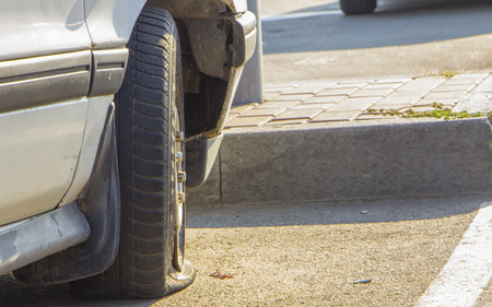 Damaged flat tire of an old car on the road with selective focusの写真素材