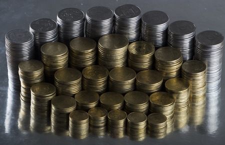 Stack of coins on a metal surface close-up.の写真素材