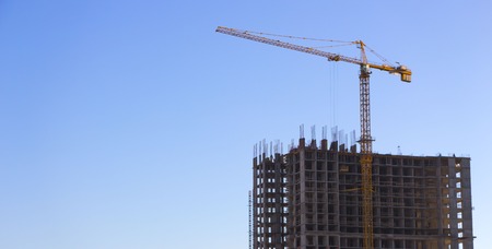 Red industrial construction crane against blue skyの写真素材