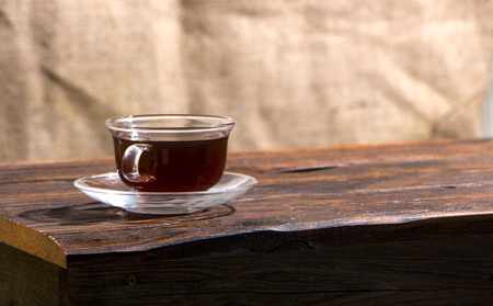 A cup of hot herbal tea and cookies on the old wooden background.の写真素材
