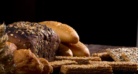 Rural bread and wheat on an old antique wooden table, still life close up