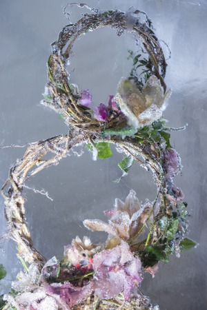 Ice sculpture of red flowers in a frozen block of iceの写真素材